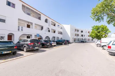 a row of cars parked in a parking lot in front of a building at Sunny House Albufeira in Albufeira