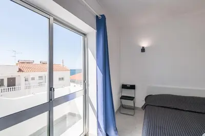 a bedroom with a bed and a large window at Sunny House Albufeira in Albufeira