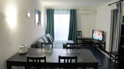 a living room with a table and a couch at CASA ROMAN Poente da Aldeia in Albufeira