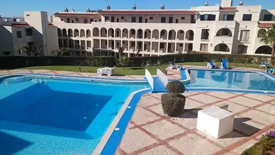 a swimming pool in front of a large building at CASA ROMAN Poente da Aldeia in Albufeira