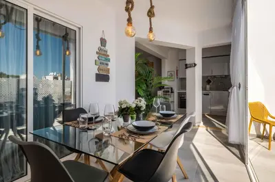 a dining room with a glass table and chairs at Salgados 2-Bedroom Apartment - 900m from the Beach - Wifi in Guia