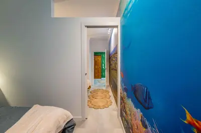 a room with a blue wall and a hallway at Salgados 2-Bedroom Apartment - 900m from the Beach - Wifi in Guia
