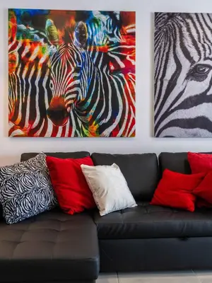 a couch with two paintings of a zebra at Salgados 2-Bedroom Apartment - 900m from the Beach - Wifi in Guia