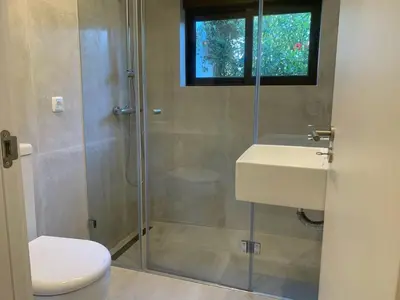 a bathroom with a shower and a toilet and a sink at Villa Hibiscus, great location in Vilamoura, lush green lawns and garden in Quarteira