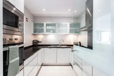 a kitchen with white cabinets and a sink at Vilamoura Pine Hills Villa in Vilamoura