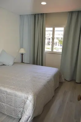 a bedroom with a white bed and a window at Marina Plaza, Vilamoura in Vilamoura