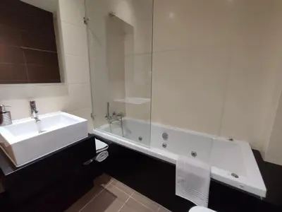 a white bathroom with a tub and a sink at Casa Felicidade in Albufeira