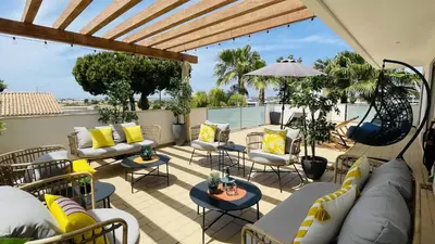 a patio with couches and chairs and an umbrella at Praia by Check-in Portugal in Albufeira