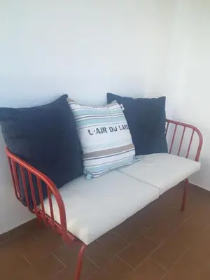 a red chair with pillows on top of it at Apartamento Sea Shell in Albufeira