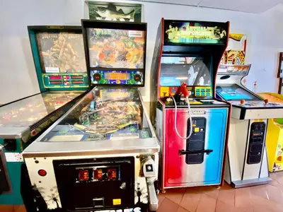 a group of arcade machines sitting next to each other at Fresh and cosy appt with Pool, Fiber, LargeTV, Gaming Room in Albufeira