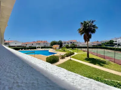 a view of a pool from a white fence at Fresh and cosy appt with Pool, Fiber, LargeTV, Gaming Room in Albufeira