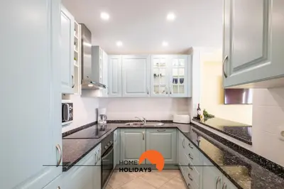 a kitchen with white cabinets and a sink at #086 Fish House by Home Holidays in Albufeira