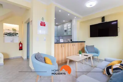 a living room with a couch and a tv on a wall at #086 Fish House by Home Holidays in Albufeira