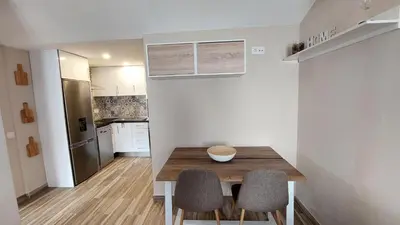 a kitchen with a wooden table and two chairs at Airport house in Faro