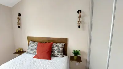 a bedroom with a bed with red and blue pillows at Airport house in Faro