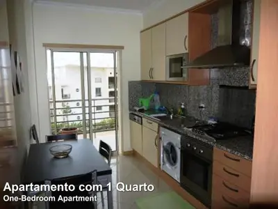 a kitchen with a table and a stove top oven at Akisol Albufeira Rainbow in Albufeira