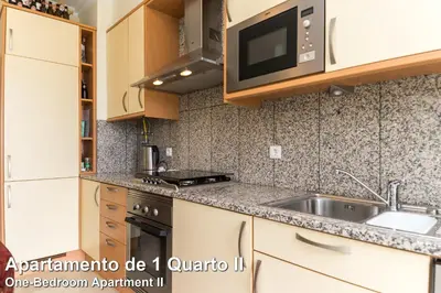 a kitchen with a sink and a microwave at Akisol Albufeira Rainbow in Albufeira