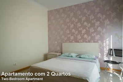 a bedroom with a bed and a purple wall at Akisol Albufeira Rainbow in Albufeira