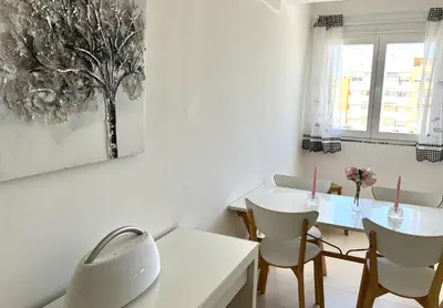 a white dining room with a white table and chairs at Nutmeg - 50mtrs to beach - by HD PROPERTIES in Quarteira
