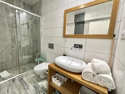 a bathroom with a sink and a shower and a toilet at Nutmeg - 50mtrs to beach - by HD PROPERTIES in Quarteira