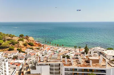 a view of a beach with buildings and the ocean at On The BEACH Stunning Apartment Albufeira Olhos de Água in Albufeira