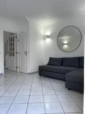 a living room with a couch and a mirror at Relaxing 2 Bedroom House 5 minutes away from Vilamoura Marina in Quarteira