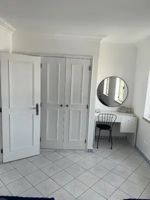 a room with two doors and a table and a mirror at Relaxing 2 Bedroom House 5 minutes away from Vilamoura Marina in Quarteira