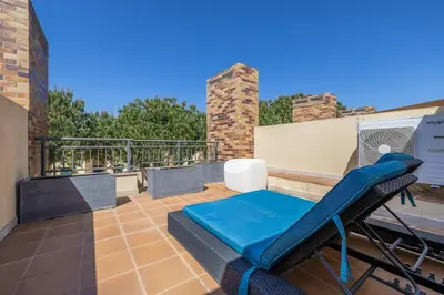 a patio with a blue bench on a roof at Vilamoura Hideaway - Golf, Pool & Beach in Vilamoura