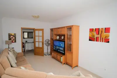 a living room with a couch and a tv at Apartamento T2 em condomínio fechado. in Albufeira