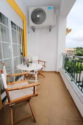 a balcony with a white table and chairs at Apartamento T2 em condomínio fechado. in Albufeira