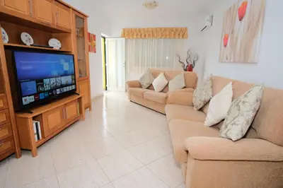 a living room with two couches and a flat screen tv at Apartamento T2 em condomínio fechado. in Albufeira