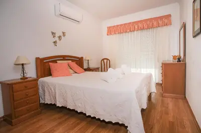 a bedroom with two beds and a dresser and a window at Apartamento T2 em condomínio fechado. in Albufeira
