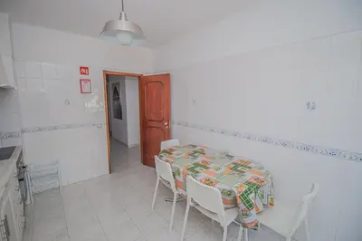 a kitchen with a table and chairs in a room at Charming Private Rooms in an Apartment A1 Penha - Faro in Faro