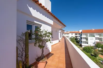 a balcony of a white building with potted plants at Beco do Sol, Albufeira in Albufeira