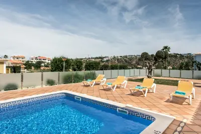 a swimming pool with lounge chairs and a swimming pool at Villa Das Oliveiras amazing location walk to Marina restaurants beach in Albufeira