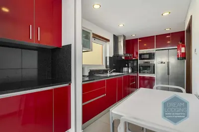 a kitchen with red cabinets and a white table at Villa Rafaella 3 - Dream Lodging in Albufeira