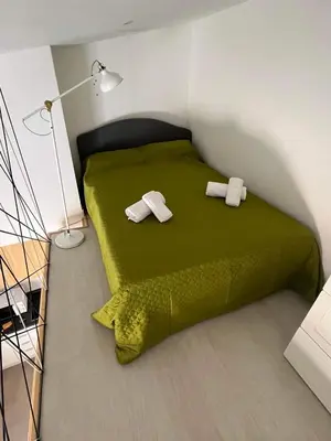 a bedroom with a green bed with two towels at CASA DAS MOURAS in Faro