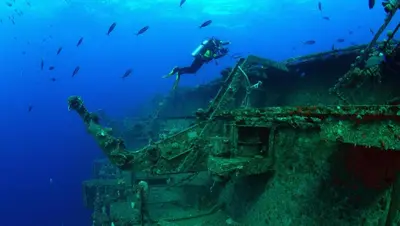 a diver is standing on a boat in the ocean at Perfect location NEW holiday apartment in Albufeira