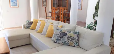 a white couch with pillows on it in a living room at Vila Rosada in Quarteira