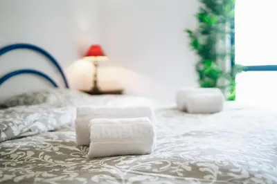 a bed with two towels sitting on top of it at Shiny Central Flat - Pool in Albufeira