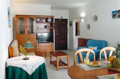 a living room with a couch and a table at Shiny Central Flat - Pool in Albufeira