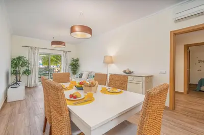 a balcony with a glass table and chairs and a swimming pool at #010 Marina by Home Holidays in Albufeira