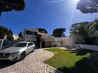 a swimming pool with lounge chairs and an umbrella at Royal Course Villa, Vale do Lobo in Vale do Lobo