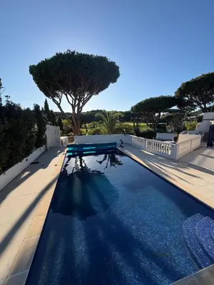 a white house with a car parked in the driveway at Royal Course Villa, Vale do Lobo in Vale do Lobo
