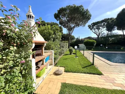 a garden with a swimming pool and a house at Vila Santo Antonio - Vilamoura by HD PROPERTIES in Vilamoura