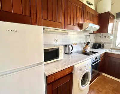 a kitchen with a white refrigerator and a dishwasher at Vila Santo Antonio - Vilamoura by HD PROPERTIES in Vilamoura