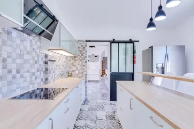 a kitchen with white cabinets and a tile floor at Villa Rimbaud in Albufeira