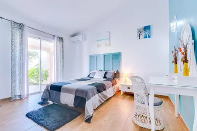 a bedroom with a bed and a desk and a window at Villa Rimbaud in Albufeira