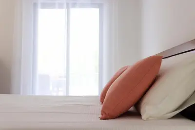 a pillow sitting on the edge of a bed at Apartamento Salgados Mar in Albufeira