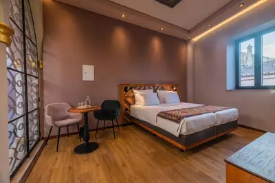 a bedroom with a bed and a table and a window at Vila Origens Boutique Hotel Albufeira – Adults Only in Albufeira
